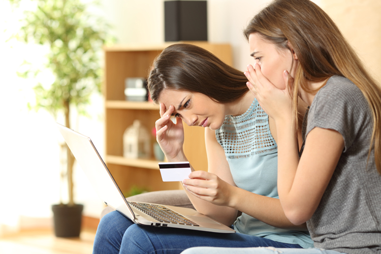 Zwei Frauen mit Kreditkarte und Laptop